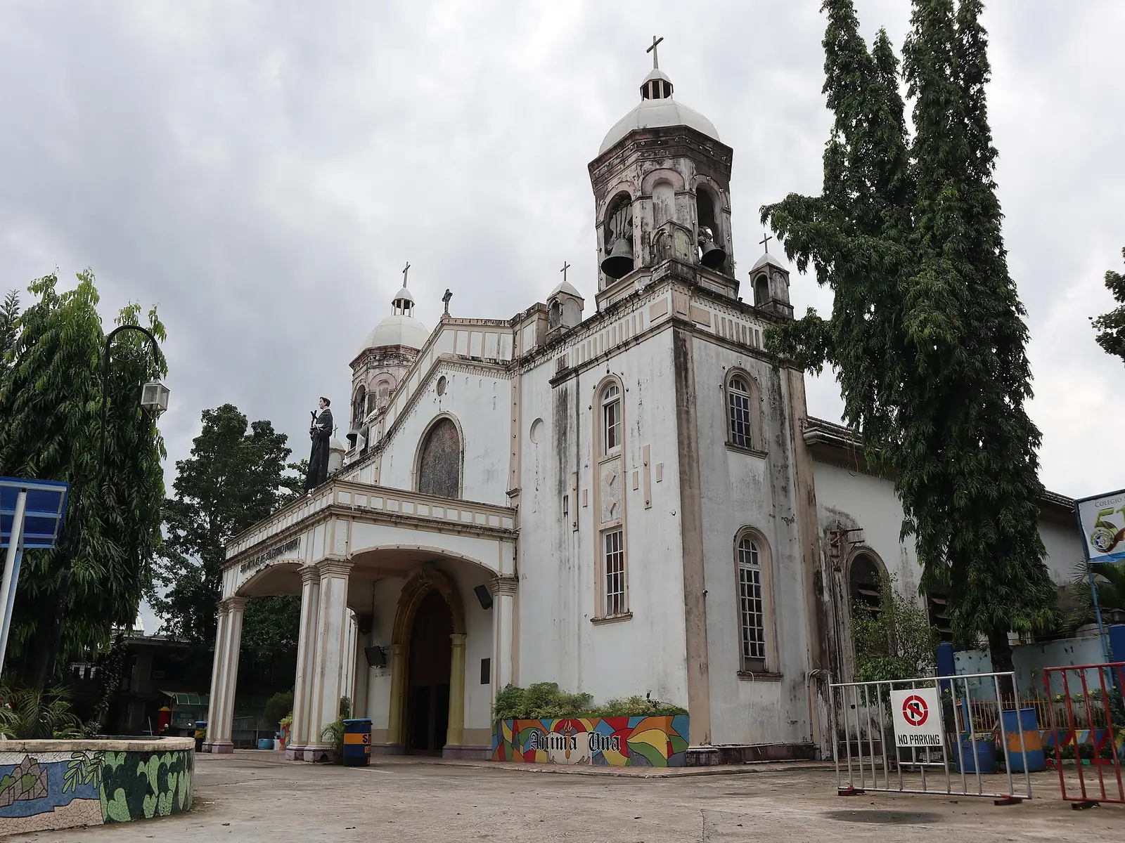 San Nicolas de Tolentino Church in Talisay, a stone church with a bell tower on a town street